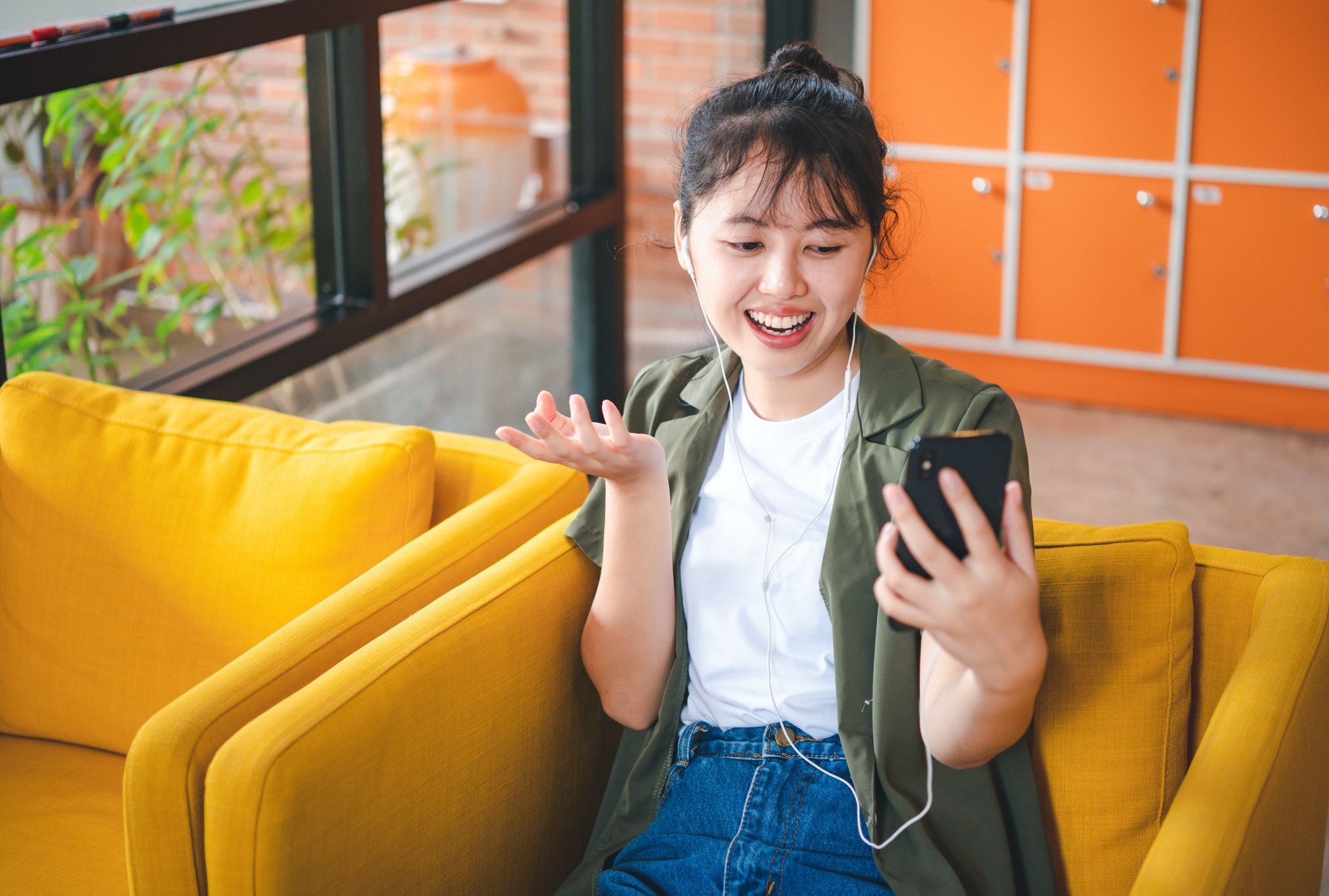 Smiling young asian woman using mobile phone checking social media