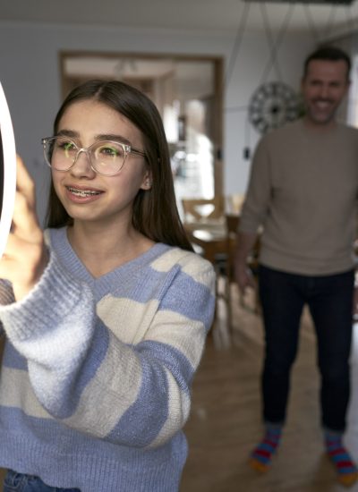 Teenager girl with parents recording dancing for social media